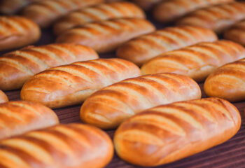 a bunch of bread lined up at a food tray