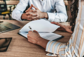 close up of a businesswoman signing a food truck insurance policy at an office table