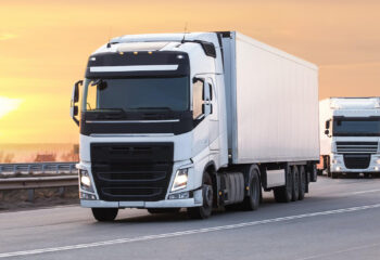 white day cab trucks move on the country highway