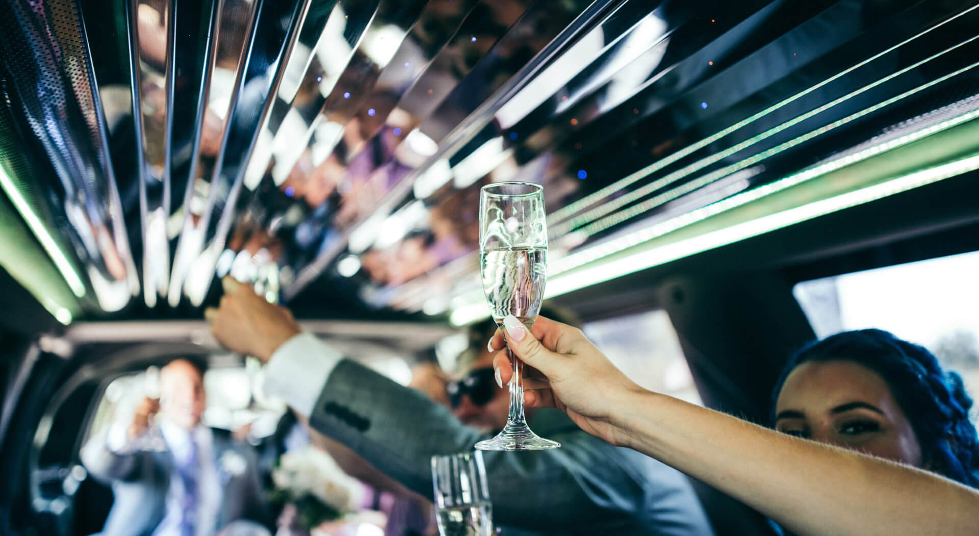 woman holding a champagne glass at a wedding party inside a limo